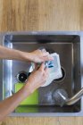 Крупним планом жінка миє посуд в кухонній мийці — стокове фото