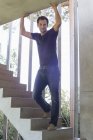 Улыбающийся мужчина, стоящий на ступеньках дома — стоковое фото