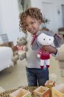 Retrato de niña de pie con muñecas en la habitación - foto de stock