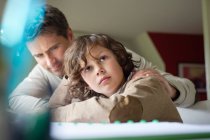 Boy thinking while studying with his father at home — Stock Photo