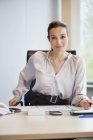 Portrait of confident businesswoman working at desk in office — Stock Photo
