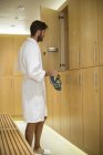 Man putting shoes in locker room at spa — Stock Photo