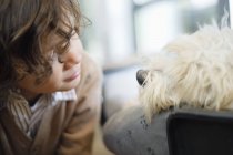 Close-up of boy looking at cute white dog — Stock Photo