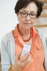 Mulher idosa em óculos leitura prescrição — Fotografia de Stock