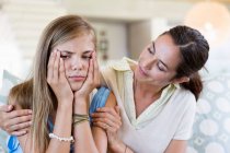Mulher persuadindo sua filha chateada em casa — Fotografia de Stock