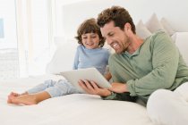 Mann zeigt seinem Sohn ein digitales Tablet — Stockfoto