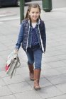 Portrait of schoolgirl carrying schoolbag on street — Stock Photo