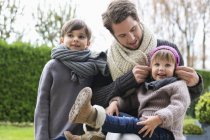 Uomo con figlio e figlia in abiti caldi in un parco — Foto stock