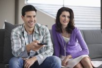 Couple watching television on couch at home — Stock Photo
