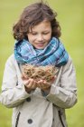 Portrait of smiling boy holding a bird nest outdoors — Stock Photo