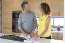 Couple cleaning kitchen together after cooking — Stock Photo