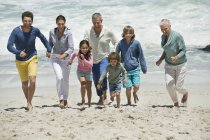 Família feliz se divertindo na praia de areia — Fotografia de Stock