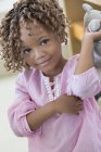 Portrait of cute little girl holding a rag doll — Stock Photo