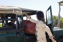 Mulher colocando saco no veículo para viajar — Fotografia de Stock