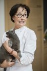Graue Katze knurrt auf Seniorin ein — Stockfoto