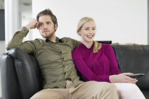 Casal assistindo televisão no sofá na sala de estar — Fotografia de Stock