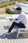 Selbstbewusster Mann nutzt Smartphone auf Terrasse in der Natur — Stockfoto