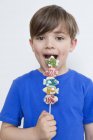Портрет милого мальчика, поедающего конфеты на палочке — стоковое фото