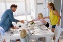 Giovane famiglia godendo il cibo in veranda — Foto stock