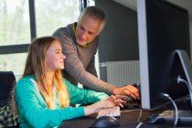 Menina usando um computador com seu pai em casa — Fotografia de Stock