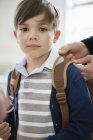 Portrait of little schoolboy with schoolbag looking at camera — Stock Photo