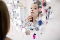Продумана дівчина-підліток дивиться на дзеркало — стокове фото