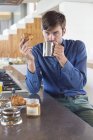 Мужчина завтракает у кухонной стойки и смотрит в камеру — стоковое фото