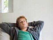 Teenager junge schlafen auf die bett — Stockfoto