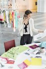 Designer de moda feminina falando no celular no escritório — Fotografia de Stock