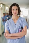 Портрет усміхненої жінки-медсестри, що стоїть з схрещеними руками — стокове фото