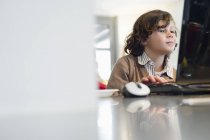 Junge benutzt Laptop am Schreibtisch zu Hause — Stockfoto