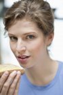 Портрет жінки, що тримає шматочок хліба і дивиться на камеру — стокове фото