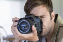 Крупним планом молодий чоловік фотографує з камерою — стокове фото