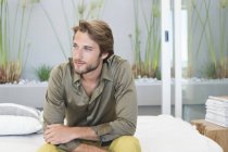 Young bearded Man sitting at home and thinking — Stock Photo