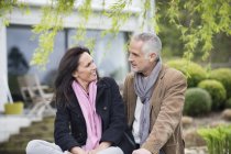 Smiling romantic couple sitting in garden in countryside — Stock Photo