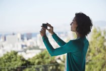 Mulher fotografando vista da cidade com telefone celular — Fotografia de Stock