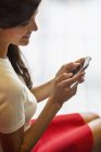 Крупним планом усміхнена жінка текстові повідомлення на мобільному телефоні — стокове фото