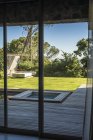 Lawn and hot tub viewed from glass door of house in countryside — Stock Photo