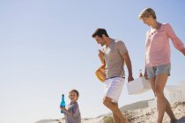 Famille heureuse en vacances marchant sur la plage — Photo de stock