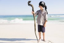 Portrait of little boy in pirate costume standing on beach — Stock Photo