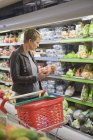 Woman buying packed food in supermarket — Stock Photo