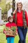 Мать и сын с ящиком домашних овощей — стоковое фото