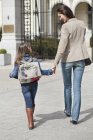 Menina com a mãe andando para a escola de mãos dadas — Fotografia de Stock