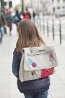 Vue arrière de la petite fille avec sac à dos marchant dans la rue — Photo de stock