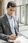 Close-up of young confident businessman text messaging — Stock Photo