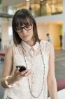 Confident businesswoman text messaging in office — Stock Photo