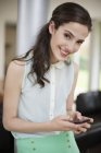 Portrait of smiling young woman using smartphone — Stock Photo