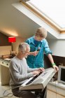Uomo che suona un pianoforte elettrico con suo figlio a casa — Foto stock