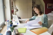 Konzentriertes Teenager-Mädchen, das zu Hause am Schreibtisch lernt — Stockfoto