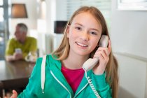 Porträt eines Mädchens, das am Telefon spricht und lächelt — Stockfoto